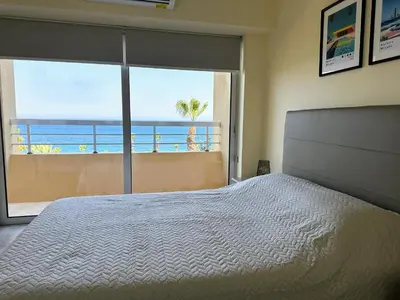 a bedroom with a bed and a view of the ocean at Seaview Apartment in Limassol in Limassol