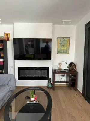 a living room with a glass table in front of a fireplace at Great Escape -Holiday House in Larnaka