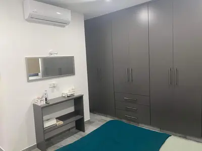 a bedroom with gray cabinets and a blue rug at Great Escape -Holiday House in Larnaka