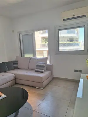 a living room with a couch and a table at Oceanside Living - Modern 1 bedroom in Limassol