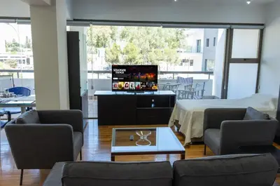 a living room with a couch and a tv at Cosy & Bright European Uni Apt in Strovolos
