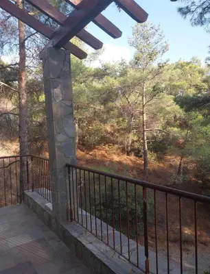 a balcony with a view of the woods at Platres Mountain Cottage in Platres
