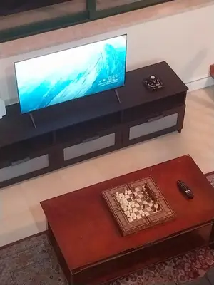a living room with a television and a chessboard on a table at Platres Mountain Cottage in Platres