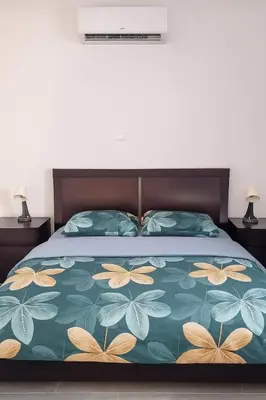 a bedroom with a bed with a bedspread with butterflies at Nissi Pearl Seaside Residence in Ayia Napa