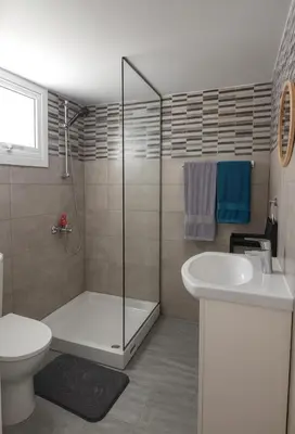 a bathroom with a shower and a toilet and a sink at Nissi Pearl Seaside Residence in Ayia Napa