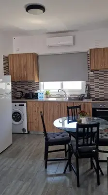 a kitchen with a table and chairs in a kitchen at Nissi Pearl Seaside Residence in Ayia Napa