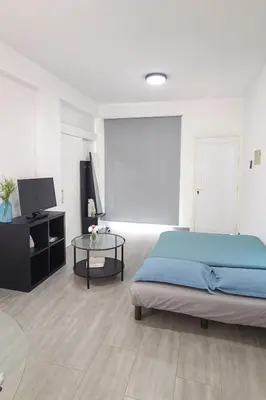 a bedroom with a bed and a tv and a table at Nissi Pearl Seaside Residence in Ayia Napa
