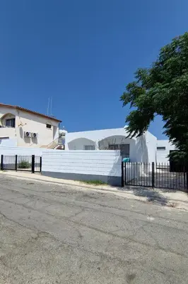 a fence in front of a white building at Nissi Pearl Seaside Residence in Ayia Napa