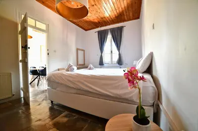 a bedroom with a bed with a flower on a table at Laouri Traditional 2-Bedroom in Kalopanayiotis in Kalopanayiotis