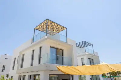 a white building with a yellow curtain in front of it at Seaside Emerald in Paralimni