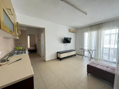 a kitchen and living room with a couch and a tv at Girne Merkez Daire in Aglantzia