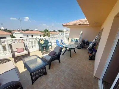 a patio with chairs and tables on a balcony at 1BR Apt, Huge Balcony, Walk to Nissi Beach in Ayia Napa