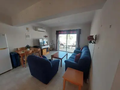 a living room with two blue couches and a table at 1BR Apt, Huge Balcony, Walk to Nissi Beach in Ayia Napa