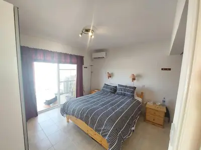 a bedroom with a bed and a large window at 1BR Apt, Huge Balcony, Walk to Nissi Beach in Ayia Napa