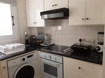 a kitchen with a stove and a sink and a dishwasher at Efterpis12 St. House in Paralimni