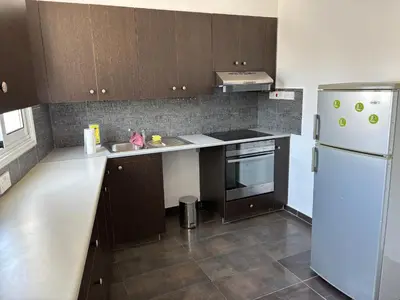 a kitchen with a white refrigerator and brown cabinets at Michaela's place in Aglantzia