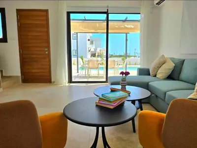 a living room with a couch and a table with books on it at Larnaca Villa in Sophtadhes