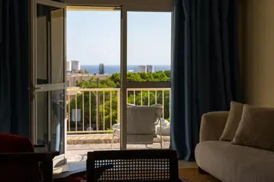a living room with a couch and a view of a balcony at Seaview apartment newly renovated to high quality in Ayia Napa