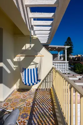 a porch with a hammock on the side of a house at Seaview apartment newly renovated to high quality in Ayia Napa
