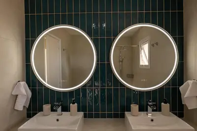 a bathroom with two sinks and two mirrors at Seaview apartment newly renovated to high quality in Ayia Napa