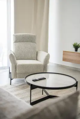 a living room with a chair and a coffee table at Serene Gardens 2BR w Pool in Livadhia