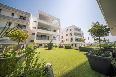 a courtyard of a building with trees and plants at Serene Gardens 2BR w Pool in Livadhia
