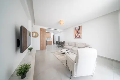 a living room with a couch and a table at Serene Gardens 2BR w Pool in Livadhia