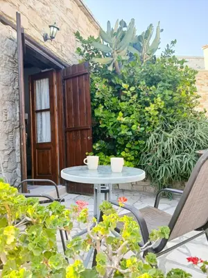 a patio with a table and chairs in front of a building at Traditional Cozy Retreat in Skarinou