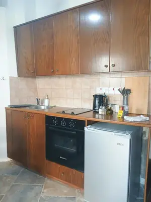 a kitchen with wooden cabinets and a black stove top oven at Traditional Cozy Retreat in Skarinou