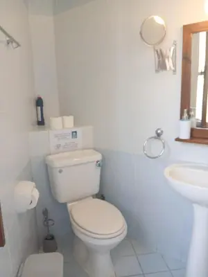 a white bathroom with a toilet and a sink at Traditional Cozy Retreat in Skarinou