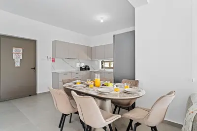 a dining room with a table and chairs in a kitchen at St Nicholas Luxury 3-Bed Villa in Paralimni