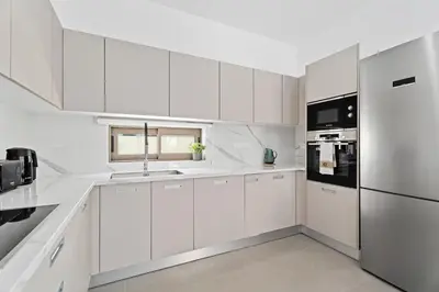 a white kitchen with a sink and a refrigerator at St Nicholas Luxury 3-Bed Villa in Paralimni