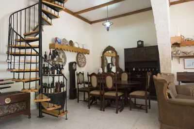 a dining room with a table and chairs and a staircase at Marianna Mansion in Pachna