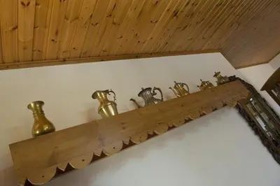 a wooden shelf with many bells on a wall at Marianna Mansion in Pachna