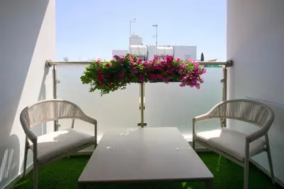 two chairs and a table with flowers on a balcony at Cosy Charming Balcony Suite in Nicosia