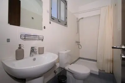 a white bathroom with a sink and a toilet at Cosy Charming Balcony Suite in Nicosia