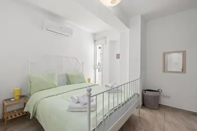 a white bedroom with a bed and a window at Giorgio Downtown 2 Bedroom Apartment in Larnaka
