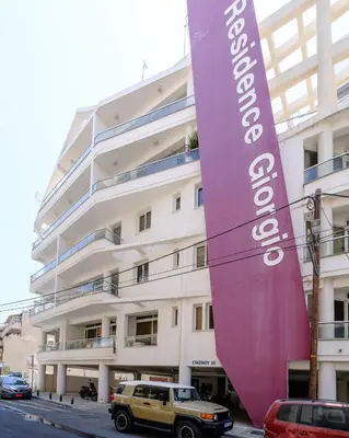 a building with a large purple banner in front of it at Giorgio Downtown 2 Bedroom Apartment in Larnaka