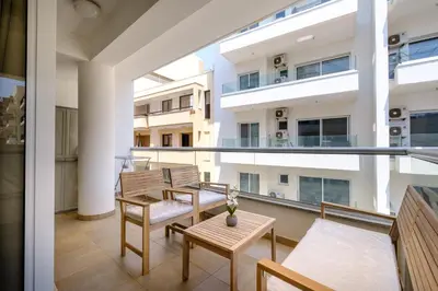 an apartment balcony with two chairs and a table at Giorgio Downtown 2 Bedroom Apartment in Larnaka