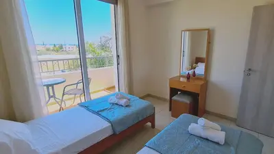 a bedroom with two beds and a mirror and a balcony at STAY Sunny Bay Villa in Protaras