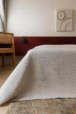 a bedroom with a white quilt on a bed at Larnaca Seaview Apartment with pool & parking in Larnaka