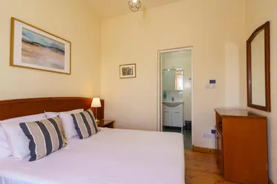 a bedroom with a bed with white sheets and pillows at Central Penthouse Sky Suite in Nicosia