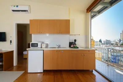 a kitchen with wooden cabinets and a large window at Central Penthouse Sky Suite in Nicosia