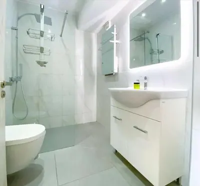 a white bathroom with a sink and a toilet at Plateia Suite Brillante in Nicosia