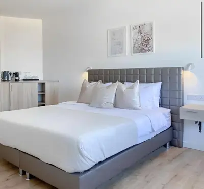 a bedroom with a large bed with white pillows at Plateia Suite Brillante in Nicosia