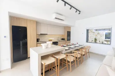 a kitchen with a table and chairs in a room at Ayia Napa Orea Villa OR8 in Ayia Napa