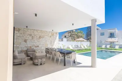 a patio with a table and chairs next to a pool at Ayia Napa Orea Villa OR8 in Ayia Napa