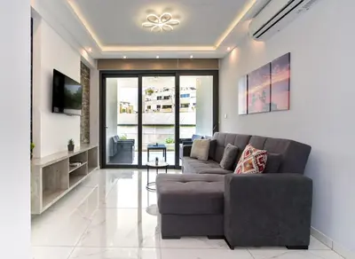 a living room with a couch and a tv at Luxury Modern Larnaca Central in Larnaka