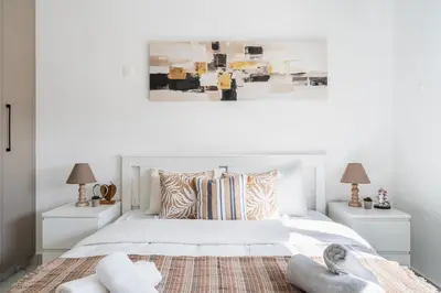 a white bedroom with a white bed and two night stands at Doria 2-Bedroom Apartment & Balcony in Larnaca in Aradhippou