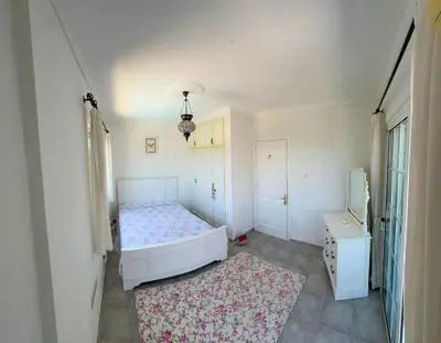 a white bedroom with a bed and a rug at Villa NATURA in Strovolos